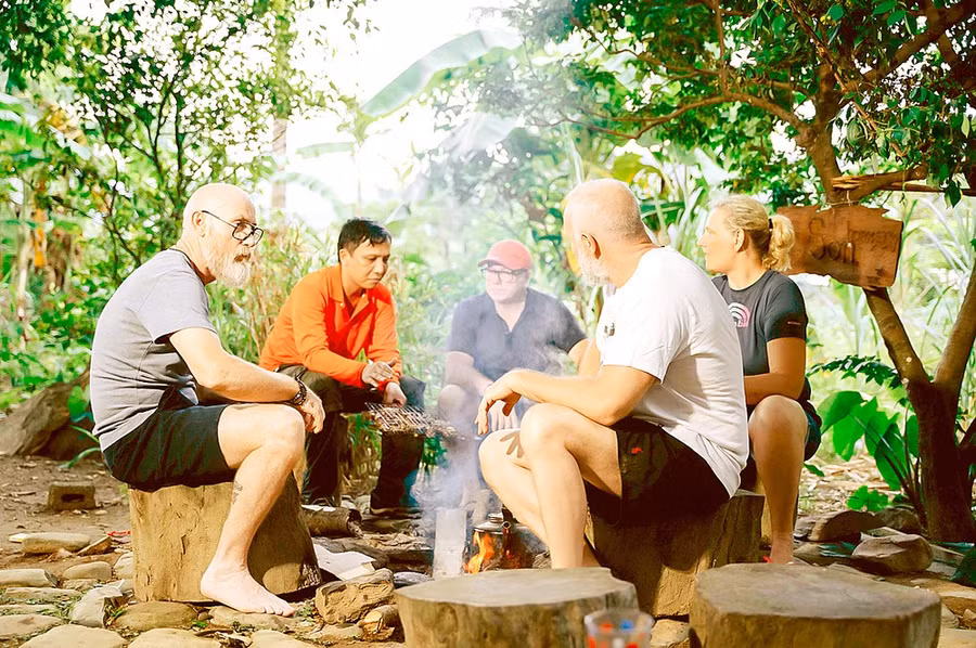 Du khách nước ngoài tham quan bản Rum Ho (xã Kim Thủy, huyện Lệ Thủy, tỉnh Quảng Bình) nghe kể về văn hóa bản địa. Ảnh: MINH PHONG