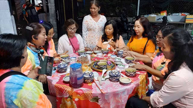 Chị Kim Lan mời khách dùng món cháo cối Chị Kim Lan mời khách dùng món cháo cối