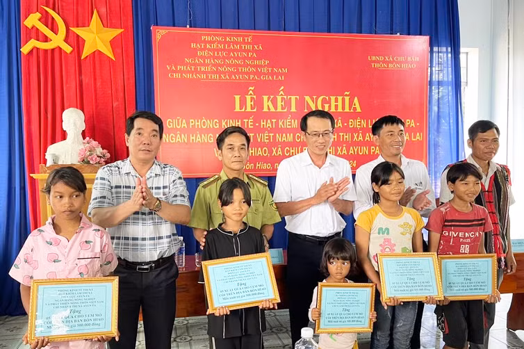 Các cơ quan, đơn vị kết nghĩa trao tặng 5 suất quà cho trẻ em mồ côi tại buôn Hiao, xã Chư Băh. Ảnh: Vũ Chi