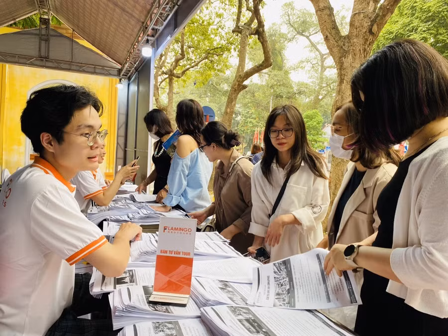 Khách tham quan Lễ hội Du lịch Hà Nội 2023 tham khảo các sản phẩm tour du lịch dịp 30.4 và hè năm nay. Để khuyến khích khách đặt dịch vụ sớm, công ty áp dụng chương trình khuyến mại cho khách đăng ký tour theo nhóm, mua tour là có quà. Ảnh: Bích Huệ
