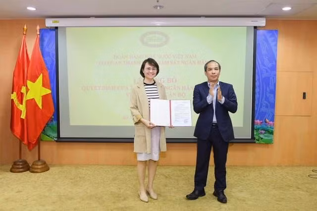 Phó thống đốc Ngân hàng Nhà nước Việt Nam Đoàn Thái Sơn trao quyết định bổ nhiệm cho bà Trần Thị Hòa