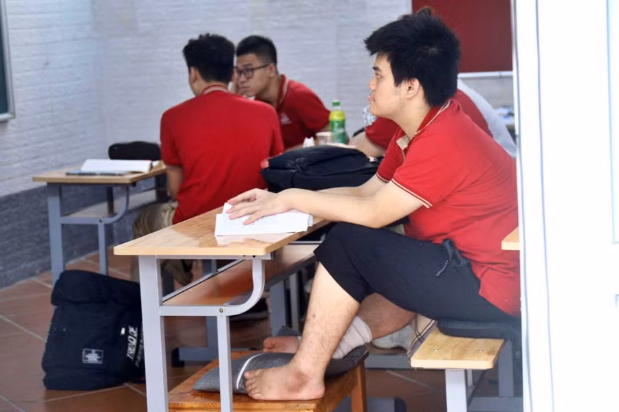 Phong được bố trí một chiếc bàn nhỏ, gối để kê chân bị thương, một chiếc gối khác để kê đầu khi mệt. Ảnh: D.T Cuộc sống 'trả nợ ân tình cuộc đời' của các nạn nhân vụ cháy chung cư mini khiến 56 người tử vong ảnh 9