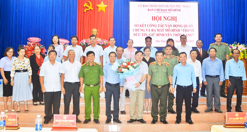 Các đại biểu tặng hoa chúc mừng huyện Phú Thiện ra mắt mô hình “Trở về đức tin, giữ bình yên thôn, làng”. Ảnh: Thúy Trinh