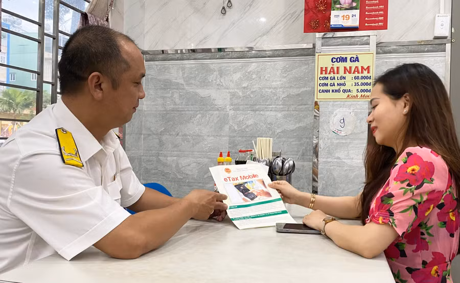 Cán bộ Chi cục Thuế TP. Pleiku tuyên truyền cho hộ kinh doanh về nghĩa vụ nộp thuế. Ảnh: Sơn Ca