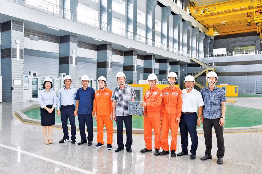 Ông Hồ Trung Đông (ở giữa, Bí thư Đảng ủy, Giám đốc Công ty Phát triển thủy điện Sê San) tặng quà cho các kíp vận hành nhân dịp Nhà máy Thủy điện Sê San 4 phát điện vượt sản lượng theo kế hoạch EVN giao năm 2022. Ảnh: Lê Phương