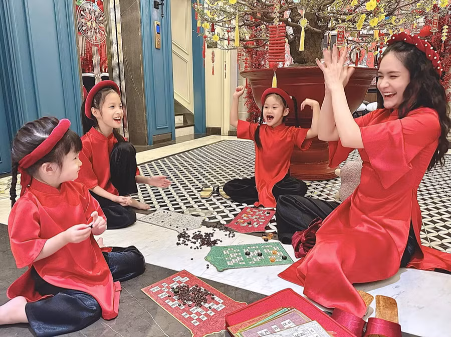 Đoàn Di Băng cùng các con diện áo dài chơi trò chơi chờ giao thừa đến: “Mấy mẹ con đang vui lắm nha. Giao thừa được đà tiến tới luôn đi“. Ảnh: Facebook nhân vật