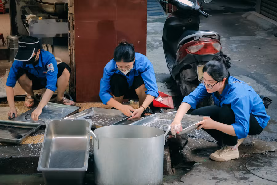 Các bạn tình nguyện viên vệ sinh dụng cụ sau buổi phát cơm