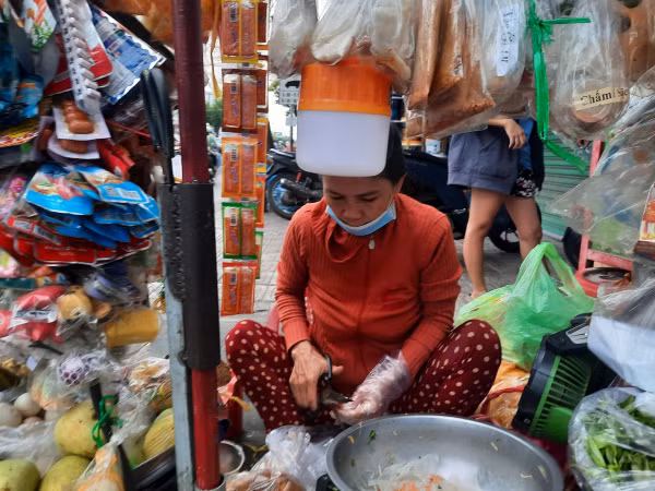 Bà Nguyệt vẫn cặm cụi với gánh hàng rong bên đường dưới cái nắng như thiêu đốt.