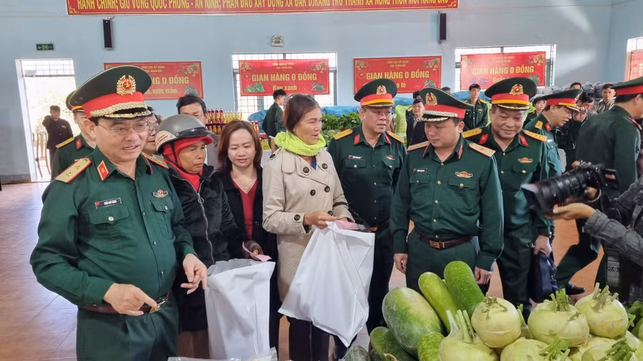 Trung tướng Trần Duy Hưng-Bí thư Đảng ủy, Chính ủy Tổng cục Kỹ thuật (bìa trái) chia sẻ cùng bà con tại phiên chợ. Ảnh: H.P