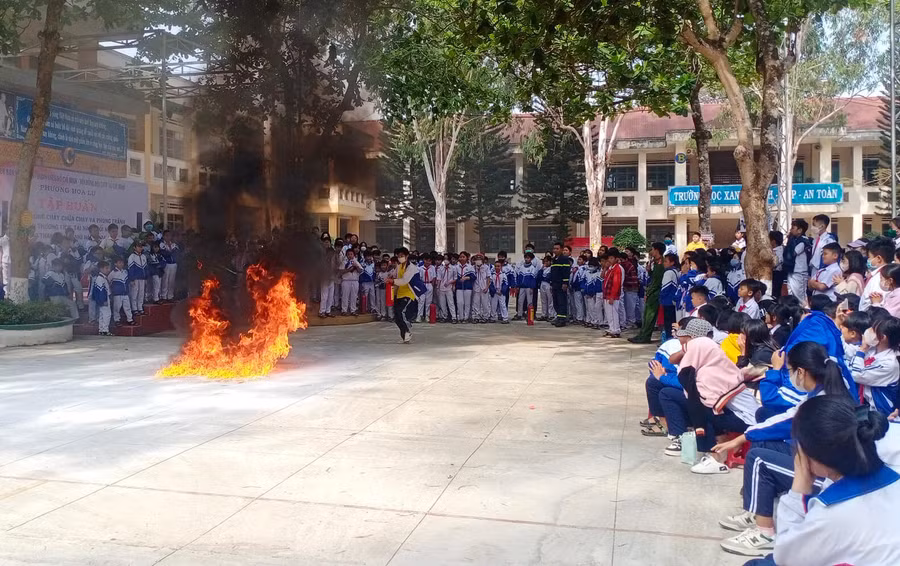 Các em học sinh được hướng dẫn dập lửa bằng bình cứu hỏa. Ảnh: K.P