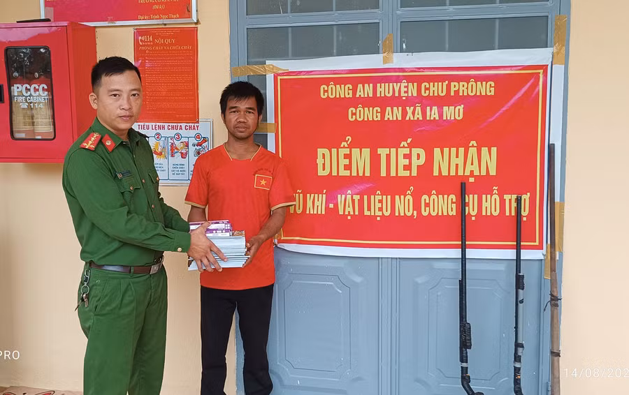 Người dân giao nộp súng tự chế đổi lấy vở, bút cho học sinh. Ảnh: Trịnh Thạch