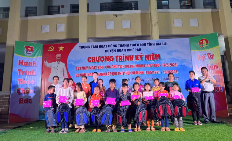 Ban tổ chức chương trình tặng quà cho các em học sinh nghèo vượt khó học giỏi. Ảnh: Văn Đại