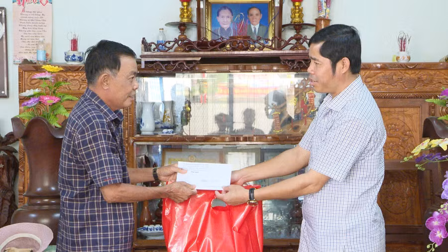 Ông Trần Minh Sơn-Tỉnh ủy viên, Bí thư Huyện ủy Chư Păh (bên phải) tặng quà cho ông Nguyễn Quyết Thắng (tổ dân phố 3, thị trấn Phú Hòa) là nạn nhân bị nhiễm chất độc da cam nhân Ngày Thương binh-Liệt sĩ (27-7). Ảnh: Văn Đại