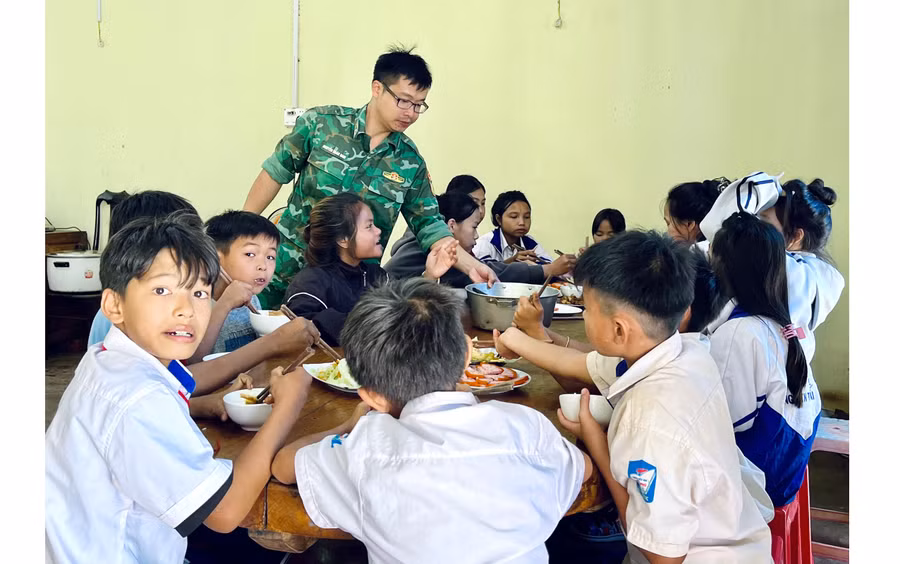 Các em học sinh ăn cơm tại “bếp ăn tình thương” của Đồn Biên phòng Cửa khẩu Quốc tế Lệ Thanh. Ảnh: V.H