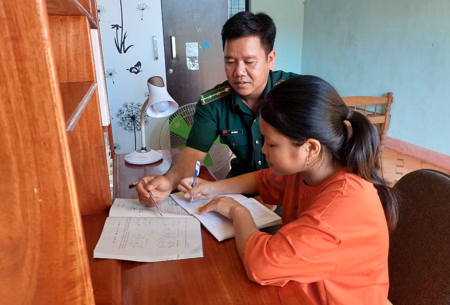 Bộ đội Biên phòng chỉ dạy con nuôi học bài. Ảnh: V.H
