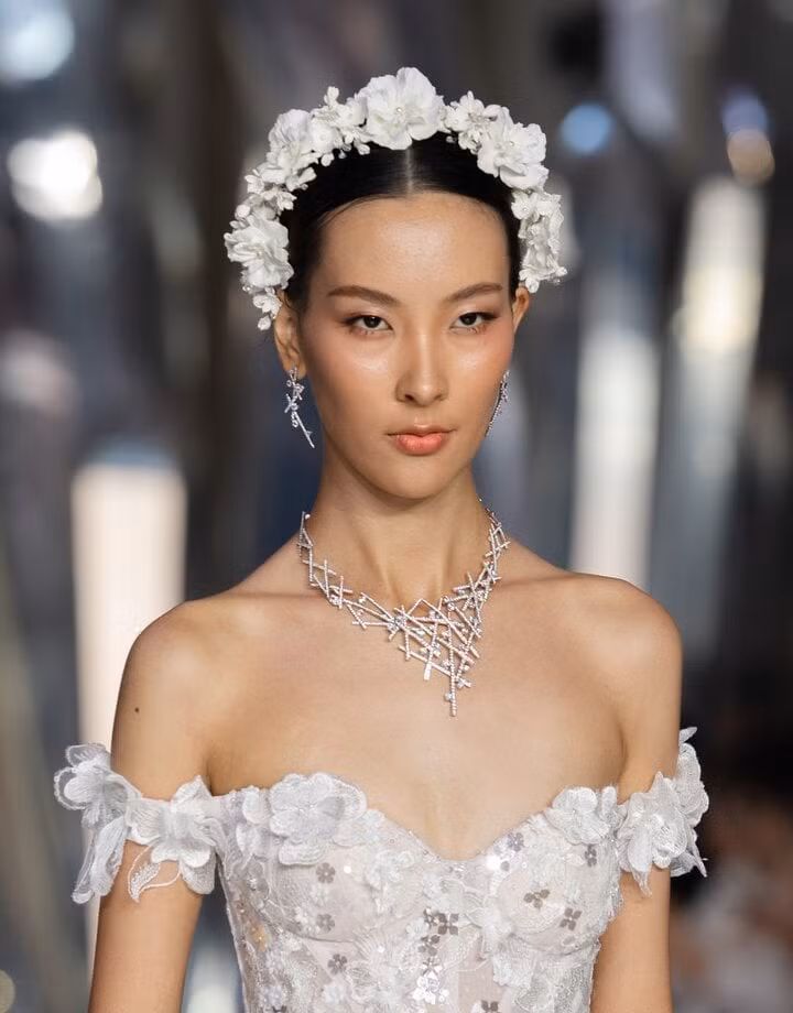 Nữ người mẫu giới thiệu chiếc vòng mang tên "Angelic Ballet", được lấy cảm hứng từ những vũ điệu uyển chuyển trong vũ trụ. Chiếc vòng đính 635 viên kim cương lab trắng nặng 28 carat, trị giá 1,1 tỷ đồng, kết hợp đồng điệu khuyên tai 178,6 triệu đồng.