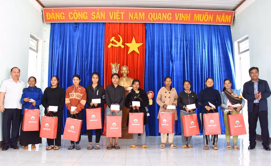 Bí thư Tỉnh ủy Hồ Văn Niên (bìa phải) và Phó Bí thư Tỉnh ủy Rah Lan Chung (bìa trái) tặng quà cho các hộ nghèo xã Chư Don. Ảnh: Đức Thụy