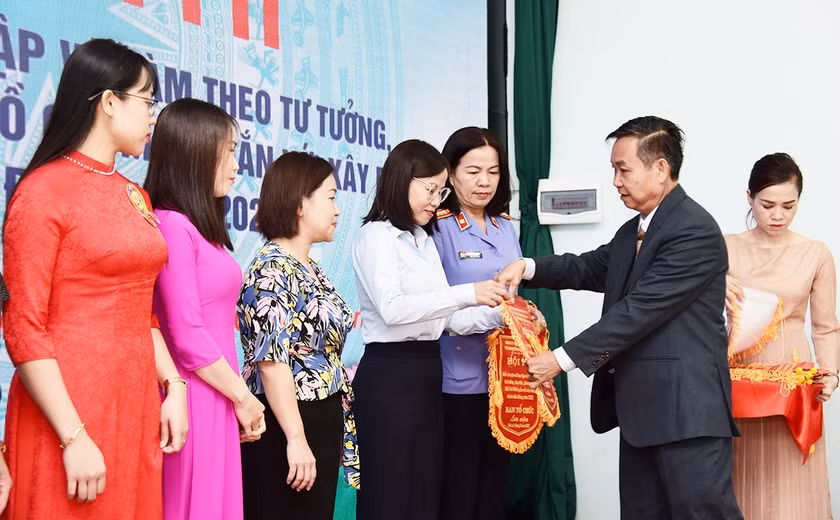 Ông Huỳnh Tấn Đoan-Phó Bí thư Đảng ủy Khối các Cơ quan và Doanh nghiệp tỉnh, Trưởng ban tổ chức Hội thi kể chuyện về học tập và làm theo tư tưởng, đạo đức, phong cách Hồ Chí Minh gắn với xây dựng, chỉnh đốn Đảng năm 2022 tặng cờ lưu niệm cho đại diện các tổ chức cơ sở Đảng có thí sinh dự thi. Ảnh: Đức Thụy