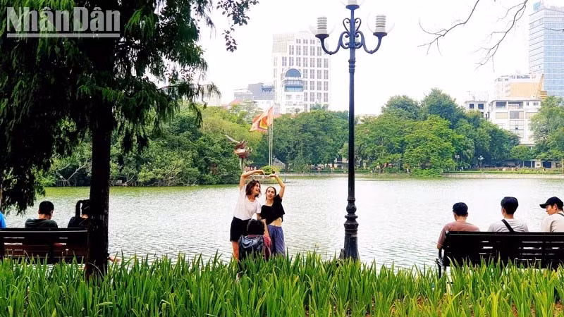 Du khách nước ngoài chụp ảnh tại Hồ Gươm, TP. Hà Nội. Ảnh: T.LINH/Nguồn NDO