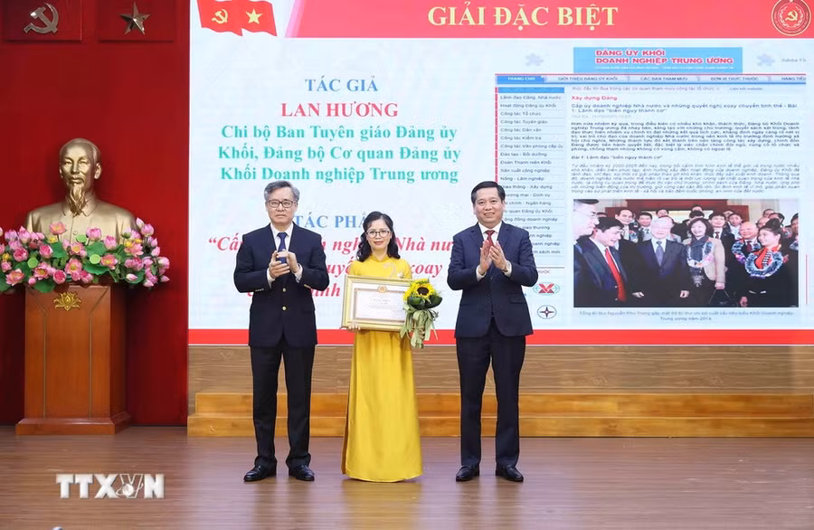 Phó Trưởng Ban Tổ chức Trung ương Nguyễn Quang Dương và Bí thư Đảng ủy Khối Doanh nghiệp Trung ương Nguyễn Long Hải trao giải Đặc biệt cho tác giả đoạt giải. (Ảnh: An Đăng/TTXVN)
