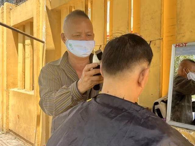 Ông Nguyễn Văn Tùng đang cắt tóc cho một vị khách quen Ông Nguyễn Văn Tùng đang cắt tóc cho một vị khách quen