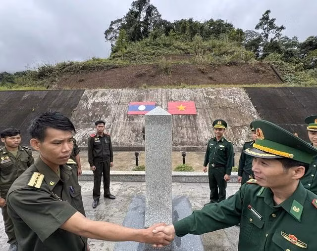 Lực lượng biên phòng VN và bảo vệ biên giới Lào bắt tay tại cột mốc đại 666 tại cửa khẩu A Đớt (H.A Lưới, Thừa Thiên - Huế) - Tà Vàng (H.Ka Lùm, Sê Kông, Lào)