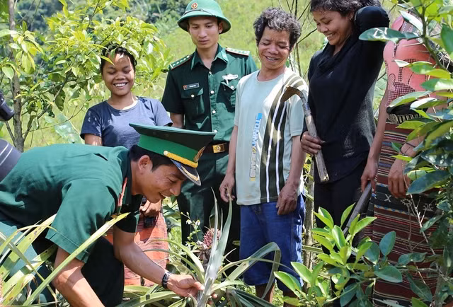 Cán bộ, chiến sĩ Đồn biên phòng cửa khẩu A Đớt hướng dẫn người dân bản Ka Lôi (H.Ka Lùm, Lào) trồng dứa...