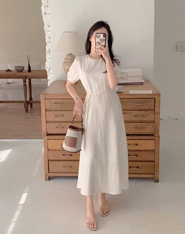 Thiết kế váy trắng cổ tròn, nhấn eo ghi điểm ở sự thanh lịch, trẻ trung. Đây là sự lựa chọn không thể thiếu của những cô nàng trong ngày hè oi bức.
