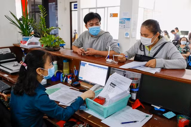 Người dân làm thủ tục tại BHXH TP HCM Ảnh: HOÀNG TRIỀU