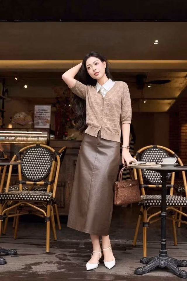 Chiếc túi xách da nâu cầm tay tiệp màu và đôi giày cao gót mũi nhọn quai mảnh màu trắng sữa hoàn thiện vẻ ngoài của một nữ tri thức thành đạt, trang nhã. Ảnh: CARDINA
