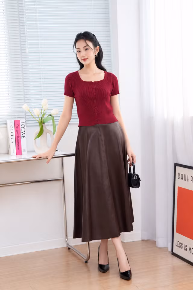 Bề mặt da bóng đặc trưng, để cân bằng lại, cách tốt nhất là phối cùng các chất liệu mềm mại như len dệt kim, vải lụa hoặc cotton thun sáng màu để hài hòa với chân váy da. Ảnh: @FIONA.VIETNAM
