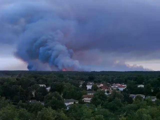 Khói bốc lên phía sau trong một vụ cháy rừng ở Saumos, tỉnh Gironde ngày 22.7.2026. Ảnh: REUTERS