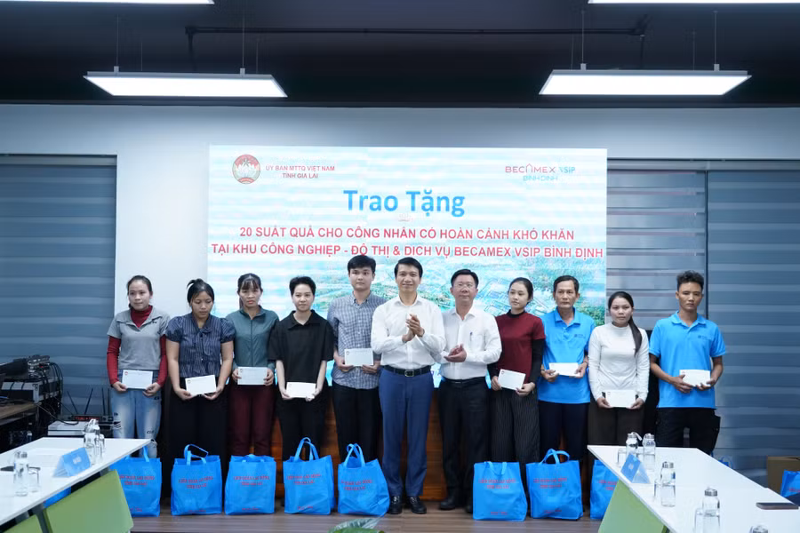 Đồng chí Nguyễn Ngọc Lương (thứ 6 từ trái sang) tặng quà cho các công nhân có hoàn cảnh khó khăn. Ảnh: N.H