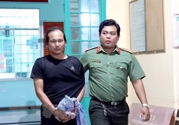 Lực lượng Công an bắt, áp giải Nguyễn Hoàng Nam về nơi giam giữ. (Ảnh: TTXVN)