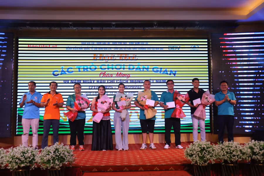 Ban tổ chức trao giải cho các VĐV nam, nữ ở môn đẩy gậy. Ảnh: Văn Ngọc