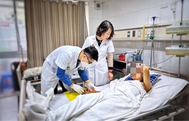 Các bác sĩ Bệnh viện Hữu nghị Việt Đức thăm khám cho bệnh nhân bị dập nát tay do pháo nổ tự chế. Ảnh nguồn Báo Lao Động