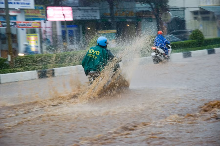 Nước ngập khoảng nửa bánh xe máy, gây nguy hiểm cho người tham gia giao thông. Ảnh: Huy Tịnh