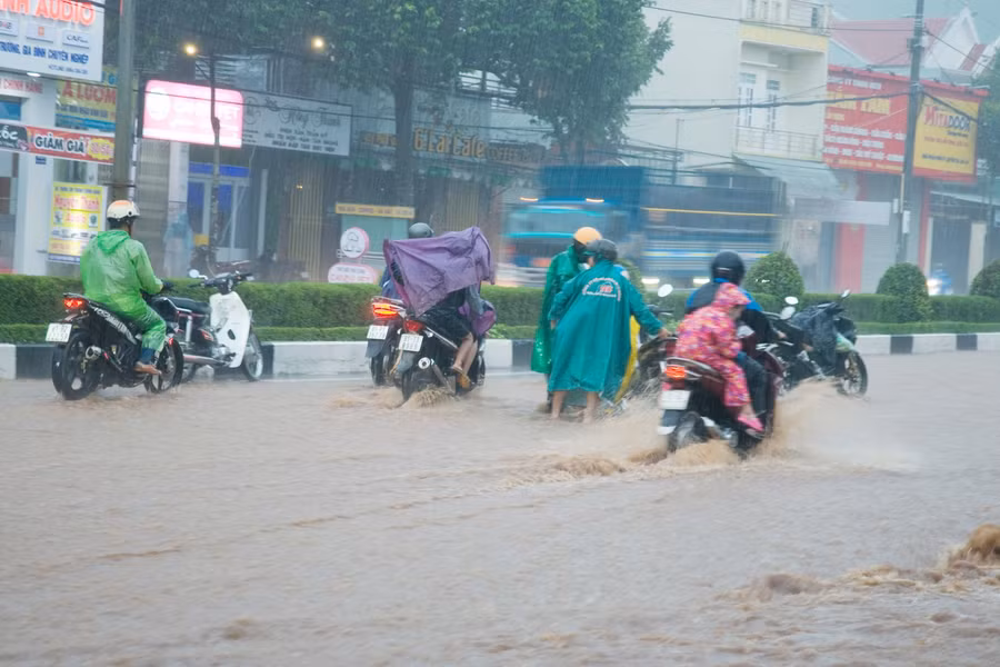 Một người điều khiển xe máy bị ngã khi đang đi trong dòng nước ngập. Rất may các phương tiện di chuyển chậm nên không xảy ra va chạm. Ảnh: Huy Tịnh