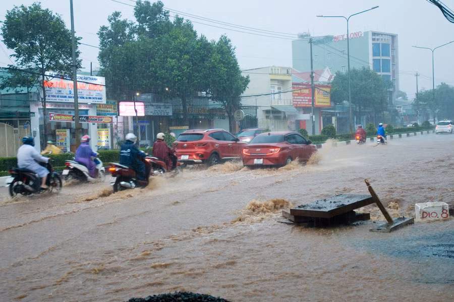 Mưa lớn, lượng nước đổ dồn quá lớn không kịp thoát đã gây ngập mặt đường khiến các phương tiện tham gia giao thông hết sức khó khăn trên đường Phạm Văn Đồng. Ảnh: Huy Tịnh