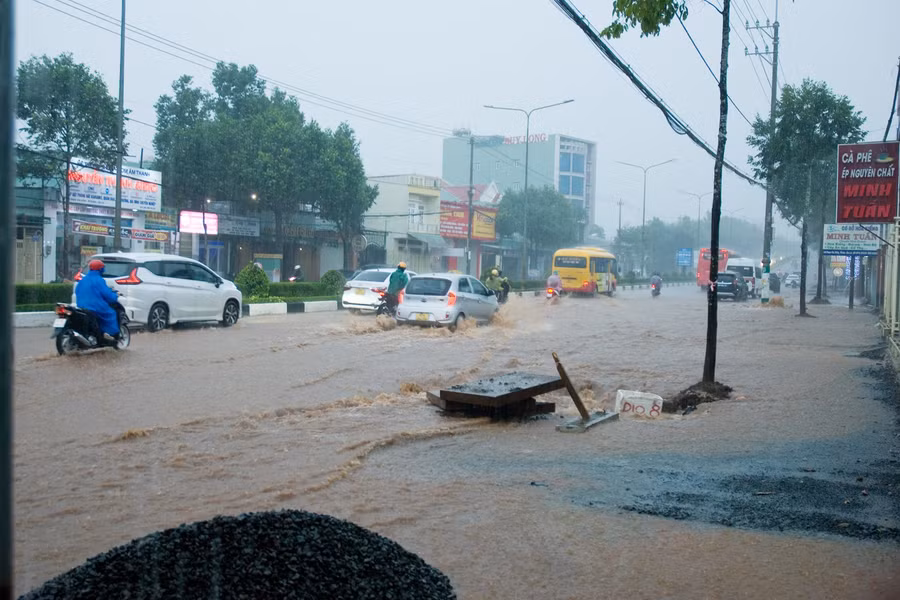 Một miệng cống thoát nước trên đường Phạm Văn Đồng đang được sửa chữa trở nên nguy hiểm cho người dân khi di chuyển trong cơn mưa chiều nay. Ảnh: Huy Tịnh