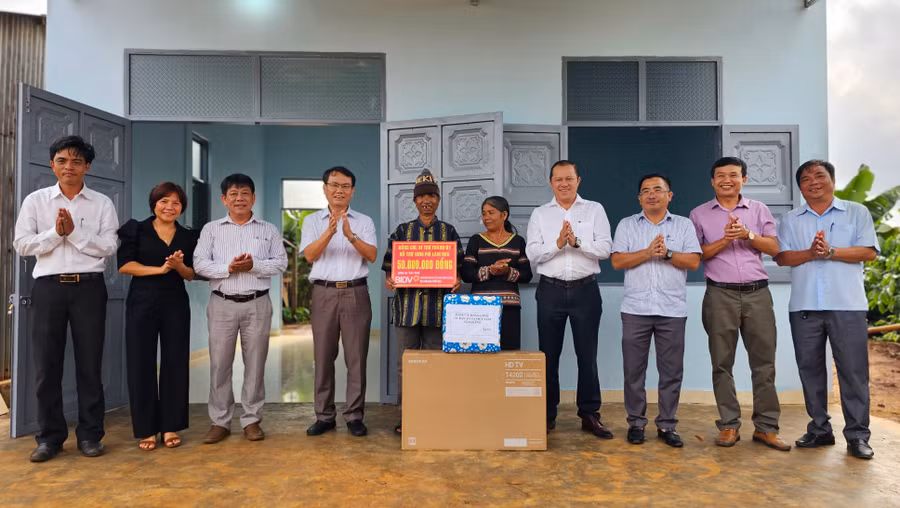 Bí thư Thành ủy Pleiku Trịnh Duy Thuân (thứ 4 từ trái sang) trao kinh phí hỗ trợ xây nhà cho hộ ông Kpă Ueng (làng Mơ Nú, xã Ia Kênh). Ảnh: Bá Bính