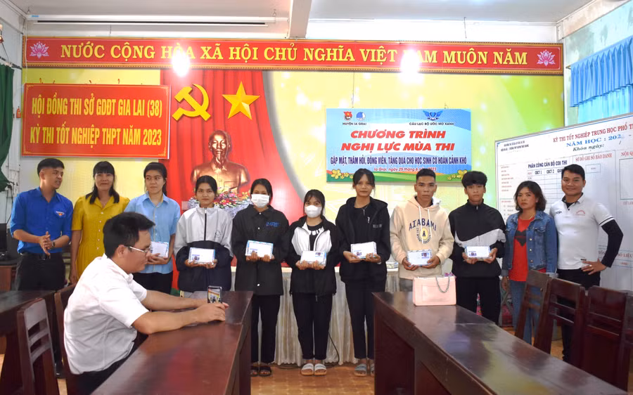 Đoàn công tác tặng quà cho các học sinh có hoàn cảnh khó khăn Trường THPT Huỳnh Thúc Kháng. Ảnh: Minh Thoan