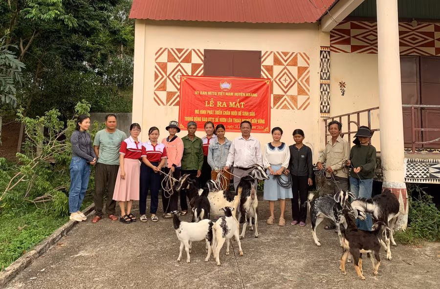 Ban vận động mô hình nuôi dê sinh sản (thứ 5 từ phải sang) tặng dê giống cho các hộ tham gia mô hình. Ảnh: Ngọc Anh