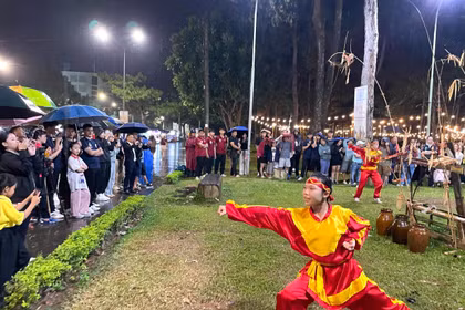 Khán giả đội mưa thưởng thức phần trình diễn võ thuật của các võ sinh đến từ Trung tâm Võ thuật cổ truyền Bình Định. Ảnh Lam Nguyên.