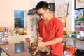 Bác sĩ thú y Nguyễn Tấn Phong tiêm phòng cho chó nuôi của khách hàng. Ảnh: H.H