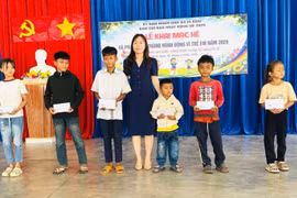 Phó Chủ tịch UBND xã Lưu Thị Thương tặng quà cho các em học sinh có hoàn cảnh khó khăn. Ảnh: ĐVCC