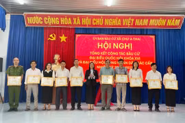 Bí thư Đảng ủy xã Trịnh Thị Hồng (đứng giữa) tặng giấy khen cho các tập thể có thành tích xuất sắc trong công tác bầu cử. Ảnh: Vũ Chi