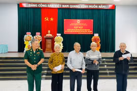 Ông Nay Phong (bìa trái, Chủ tịch Hội CCB thị xã) tặng quà cho các hội viên CCB từng tham gia cuộc kháng chiến chống Pháp. Ảnh: Vũ Chi
