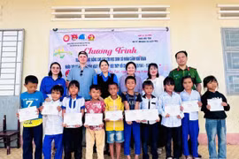 Ban tổ chức tặng học bổng cho các em học sinh nghèo tại điểm Trường Tiểu học Hùng Vương (buôn Ma Giai). Ảnh: ĐVCC
