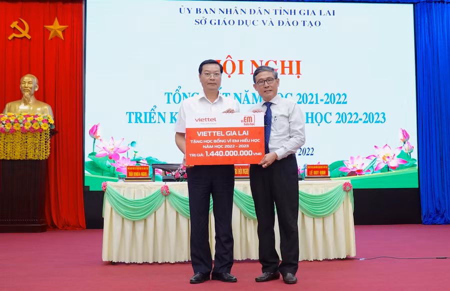 Giám đốc Viettel Gia Lai Trần Văn Thuân (bìa trái) trao bảng tượng trưng tặng học bổng 